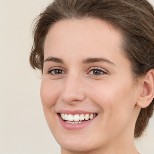 Joyful white young-adult female with medium  brown hair and green eyes