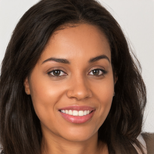 Joyful latino young-adult female with long  brown hair and brown eyes