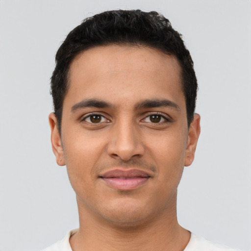 Joyful latino young-adult male with short  black hair and brown eyes