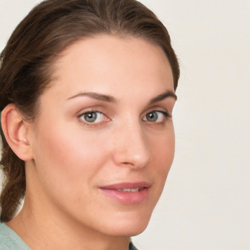 Joyful white young-adult female with medium  brown hair and green eyes