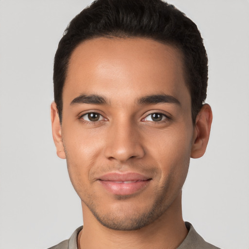 Joyful latino young-adult male with short  black hair and brown eyes