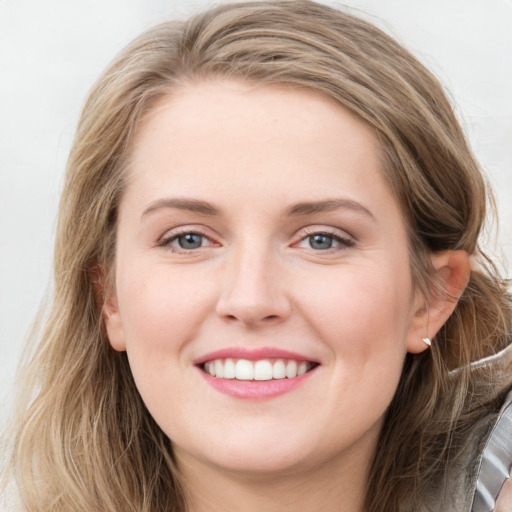 Joyful white young-adult female with long  brown hair and blue eyes