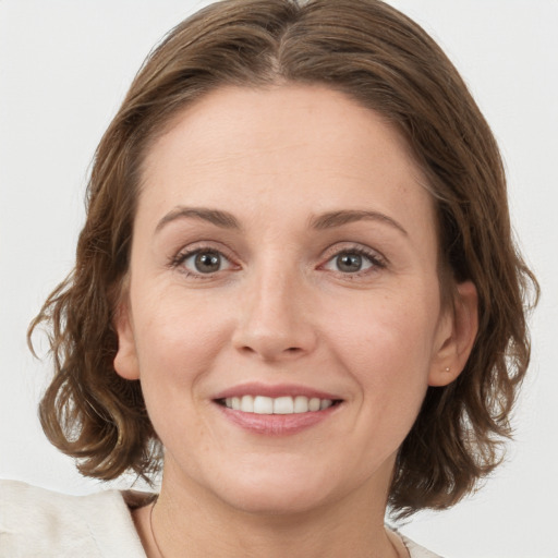 Joyful white young-adult female with medium  brown hair and grey eyes