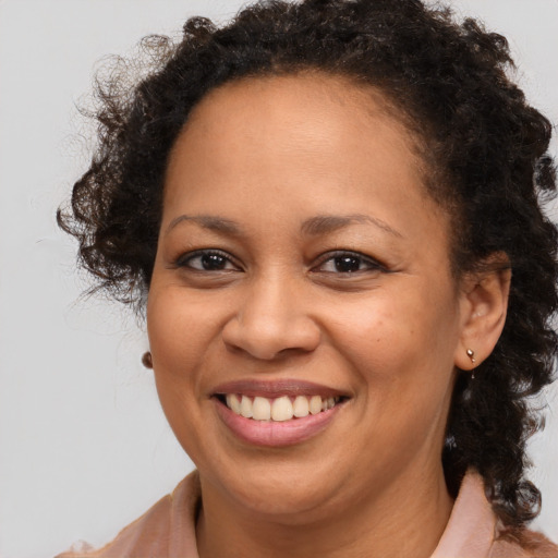 Joyful black adult female with medium  brown hair and brown eyes
