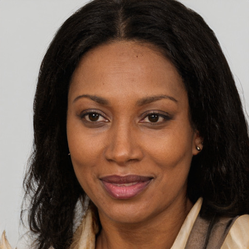 Joyful black adult female with long  brown hair and brown eyes
