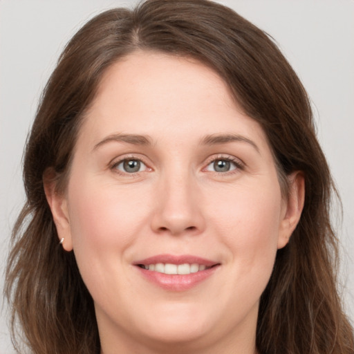 Joyful white young-adult female with long  brown hair and grey eyes