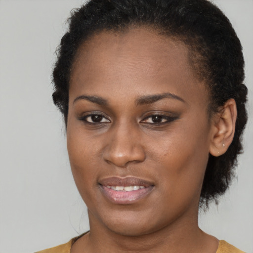 Joyful black young-adult female with short  brown hair and brown eyes