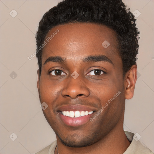 Joyful black young-adult male with short  brown hair and brown eyes