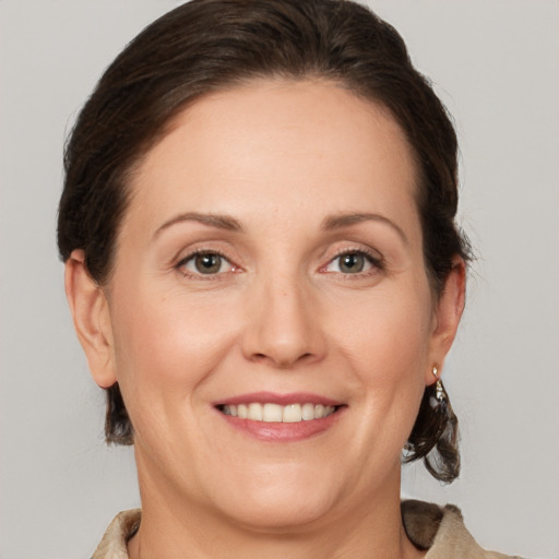 Joyful white adult female with medium  brown hair and grey eyes