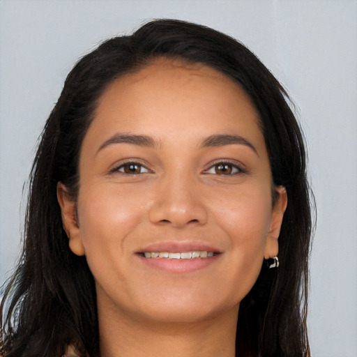 Joyful latino young-adult female with long  brown hair and brown eyes