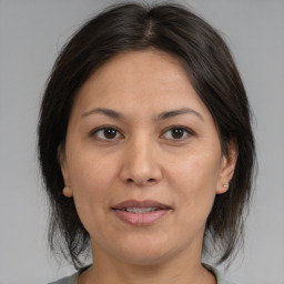 Joyful asian adult female with medium  brown hair and brown eyes