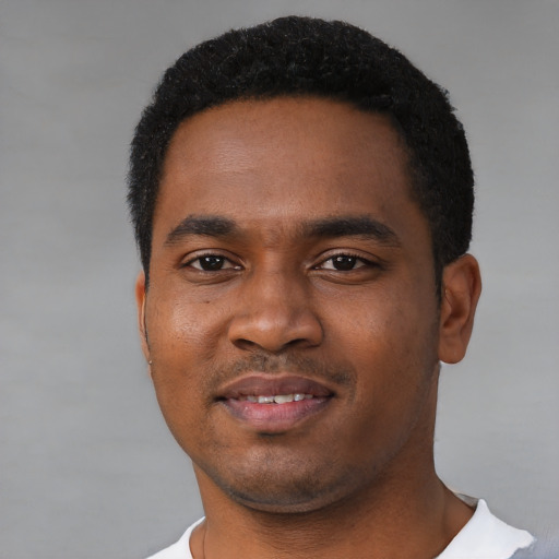 Joyful black young-adult male with short  black hair and brown eyes
