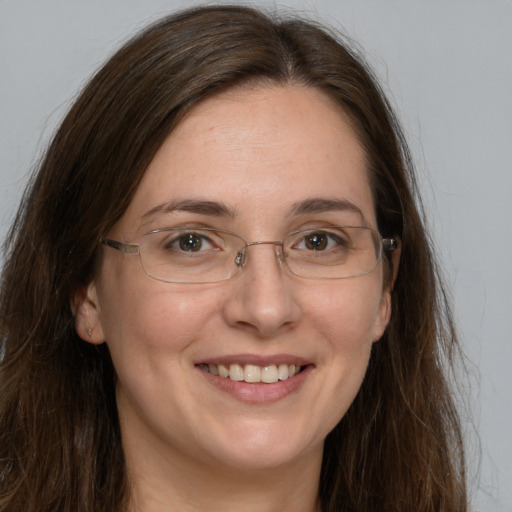 Joyful white adult female with long  brown hair and grey eyes