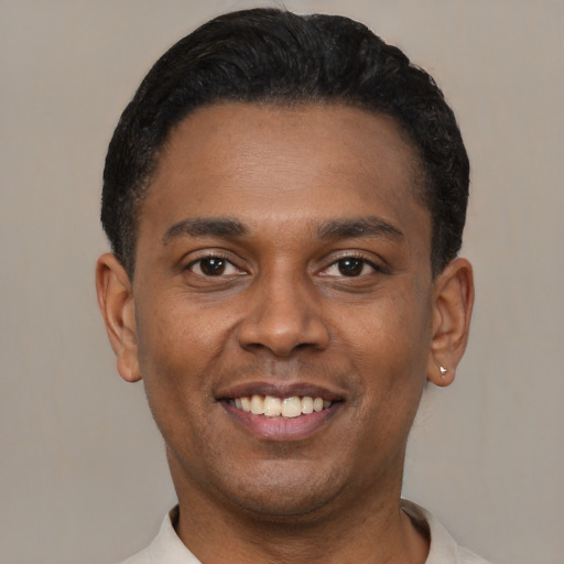 Joyful latino young-adult male with short  black hair and brown eyes