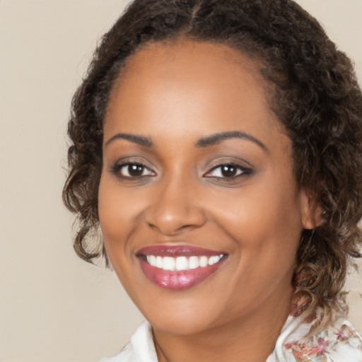 Joyful black young-adult female with medium  brown hair and brown eyes