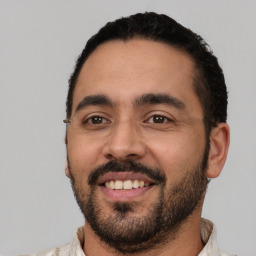 Joyful latino young-adult male with short  black hair and brown eyes