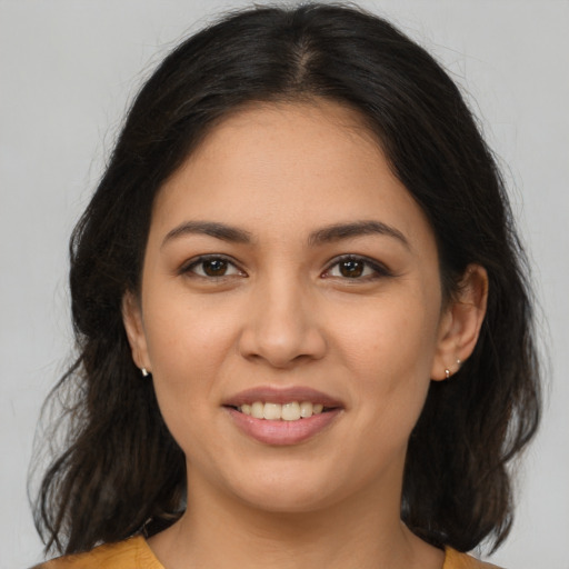 Joyful latino young-adult female with medium  brown hair and brown eyes