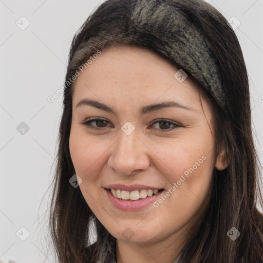 Joyful white young-adult female with long  brown hair and brown eyes