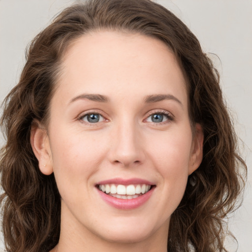 Joyful white young-adult female with long  brown hair and green eyes