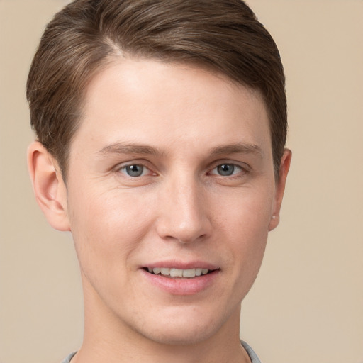 Joyful white young-adult male with short  brown hair and grey eyes