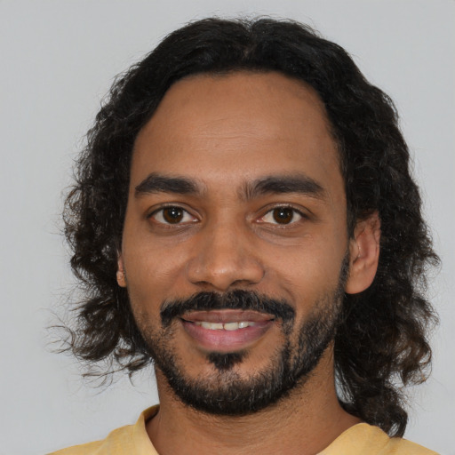 Joyful black young-adult male with short  black hair and brown eyes
