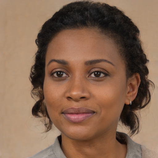 Joyful black young-adult female with medium  brown hair and brown eyes