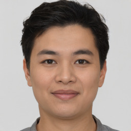 Joyful asian young-adult male with short  brown hair and brown eyes