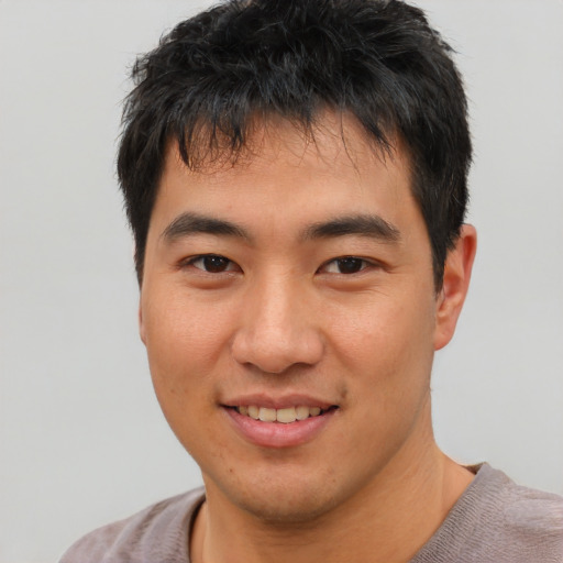 Joyful asian young-adult male with short  black hair and brown eyes