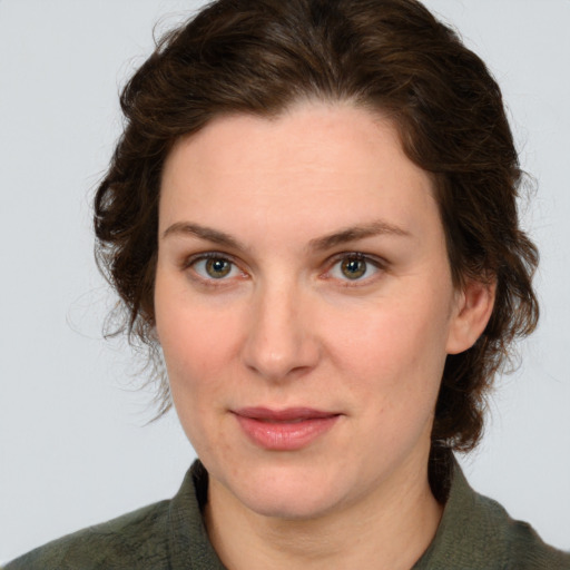 Joyful white young-adult female with medium  brown hair and green eyes