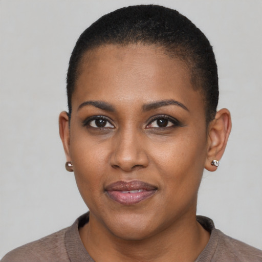 Joyful black young-adult female with short  black hair and brown eyes