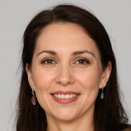 Joyful white adult female with long  brown hair and brown eyes