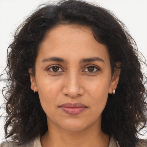 Joyful latino adult female with long  brown hair and brown eyes
