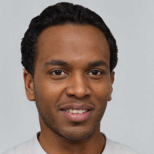 Joyful black young-adult male with short  black hair and brown eyes