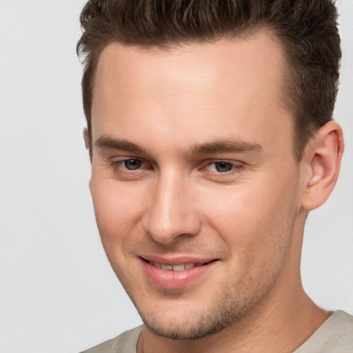 Joyful white young-adult male with short  brown hair and brown eyes