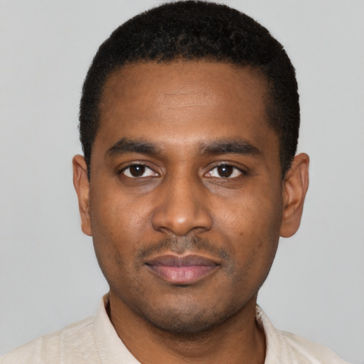 Joyful black young-adult male with short  black hair and brown eyes