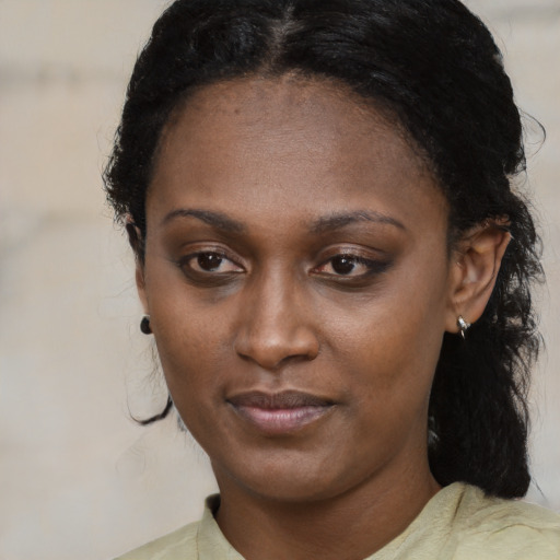 Joyful black young-adult female with medium  black hair and brown eyes