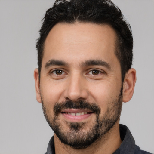 Joyful white adult male with short  black hair and brown eyes