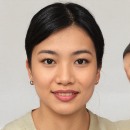 Joyful asian young-adult female with short  black hair and brown eyes