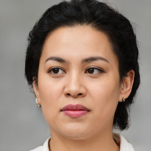 Joyful latino adult female with medium  brown hair and brown eyes
