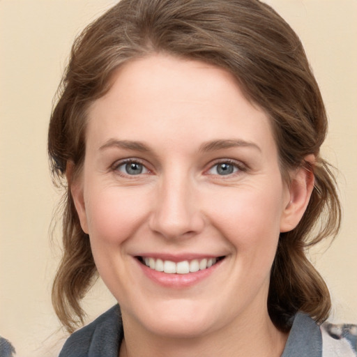 Joyful white young-adult female with medium  brown hair and grey eyes