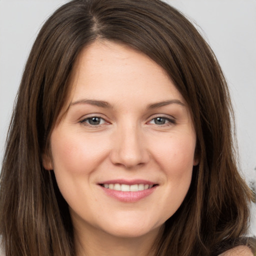 Joyful white young-adult female with long  brown hair and brown eyes