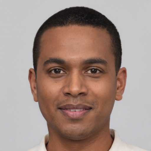 Joyful black young-adult male with short  black hair and brown eyes