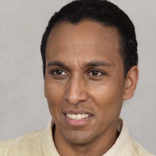 Joyful latino adult male with short  black hair and brown eyes