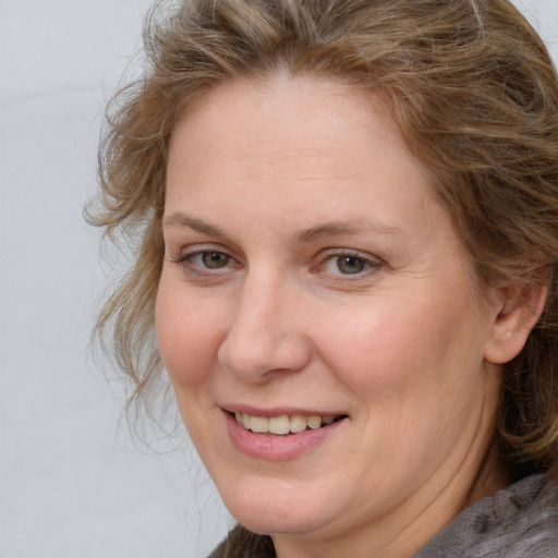 Joyful white adult female with medium  brown hair and blue eyes