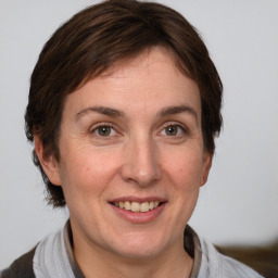 Joyful white adult female with medium  brown hair and grey eyes