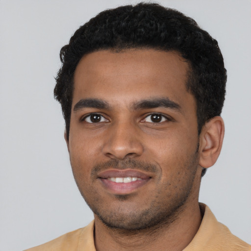 Joyful black young-adult male with short  black hair and brown eyes