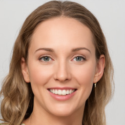 Joyful white young-adult female with long  brown hair and green eyes