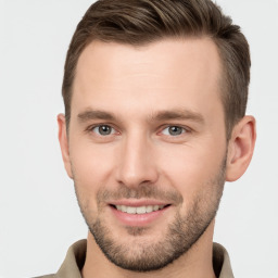 Joyful white young-adult male with short  brown hair and grey eyes