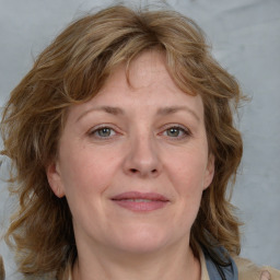 Joyful white adult female with medium  brown hair and blue eyes