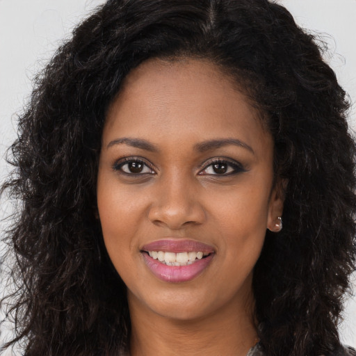 Joyful black young-adult female with long  brown hair and brown eyes